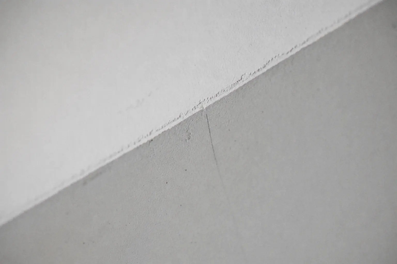 Crisp edge between a matt pure-white ceiling and a silk-grey wall, brush cut-in