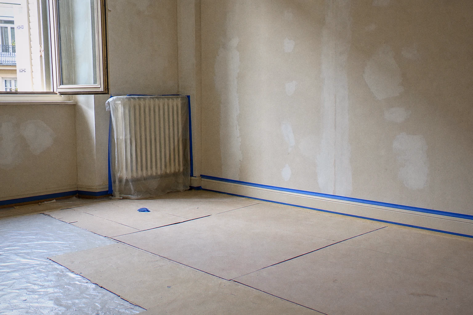 Between-tenancy repaint site in Geneva — floor covers down, joinery masked, wall in progress: Renovhome organisation