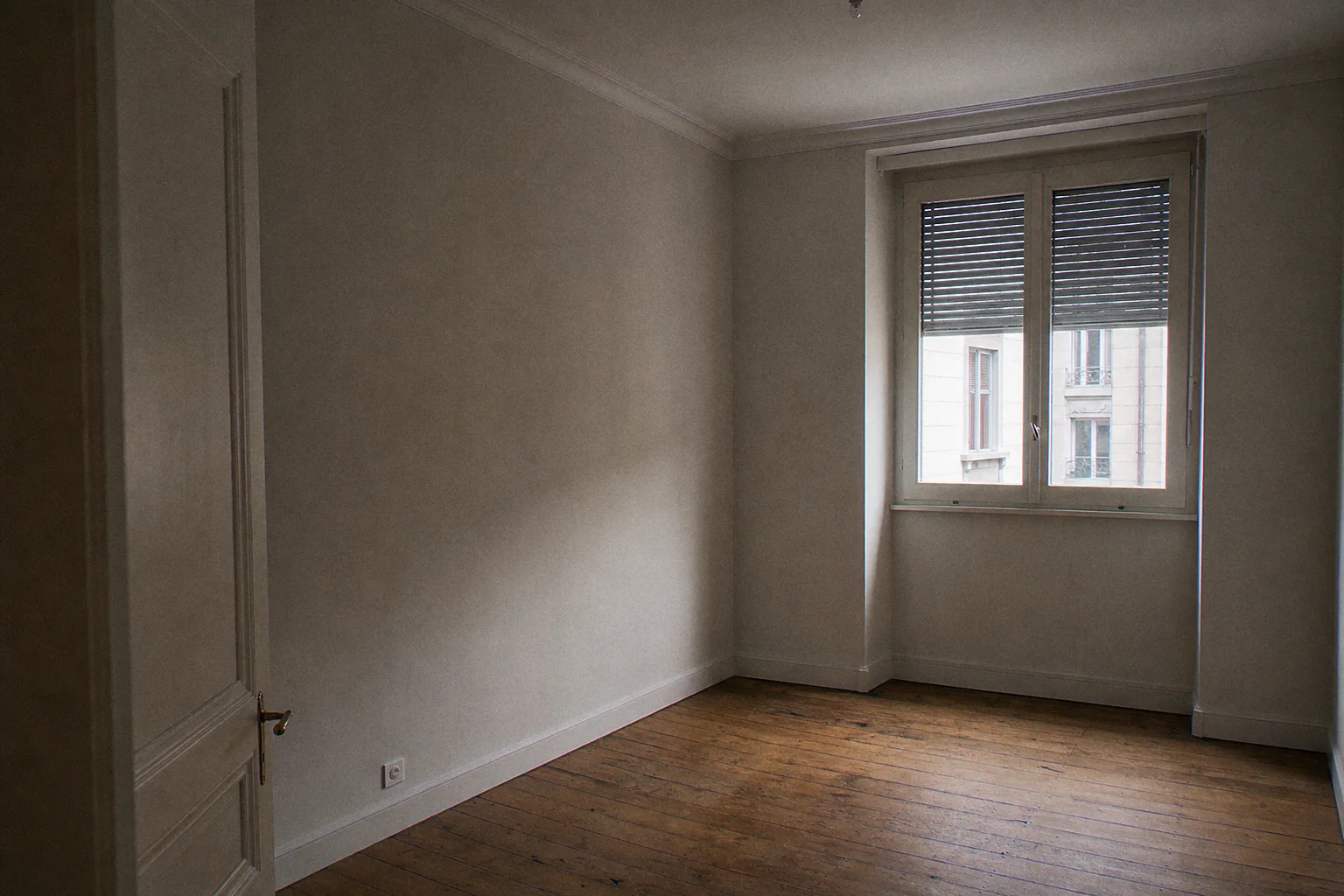 Empty bedroom refreshed: soft pearl-grey walls, old door repainted in white enamel, original oak floorboards