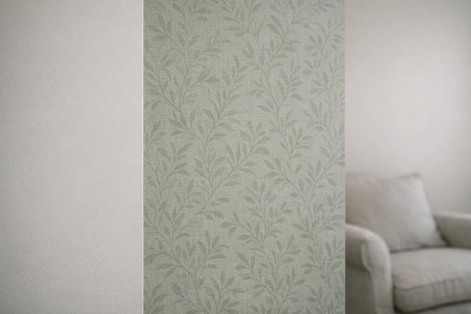 Mur recouvert d'un papier peint intissé motif végétal vert sauge
